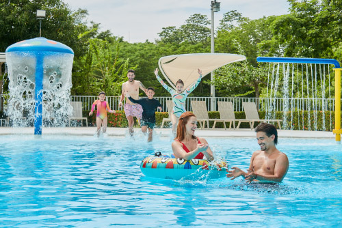Familia está compartiendo dentro de una piscina de agua cristalina que queda al aire libre y está rodeada de gran cantidad de vegetación que se puede conocer al adquirir los planes turísticos de Lagosol