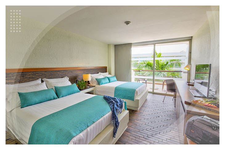 Fotografía de Lagomar, un hotel en Girardot, que muestra el baño de las habitaciones en el que se ve el lavamanos, un espejo y tres toallas de color naranja