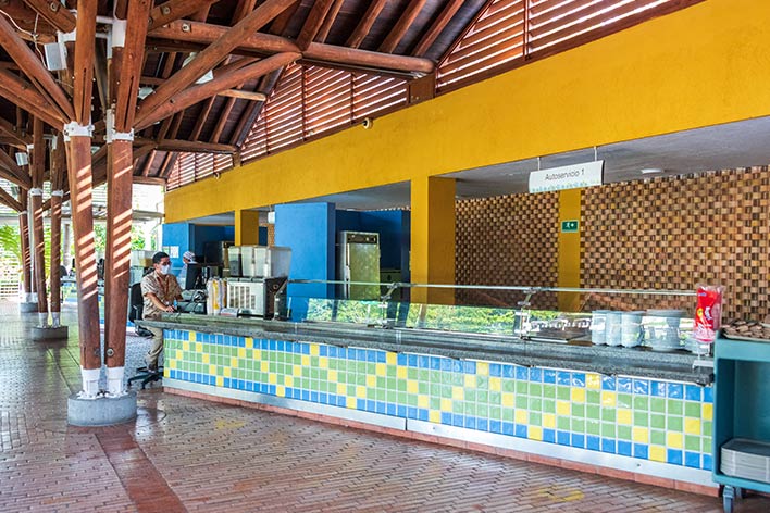 Fotografía de la zona de comidas del hotel y parque acuático Lagosol, que muestra el área de buffet y tres dispensadores de jugo
