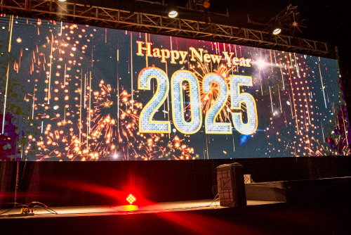 Pantalla gigante iluminada con fuegos artificiales y el mensaje “Happy New Year 2025”, como parte de un espectáculo visual durante la celebración de Año Nuevo
