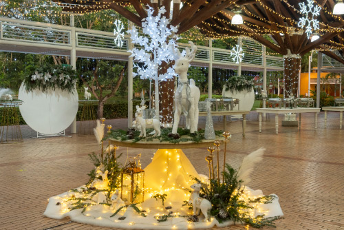 Decoración navideña en interior con árbol iluminado, adornos blancos y luces cálidas que crean un ambiente acogedor y festivo para la temporada