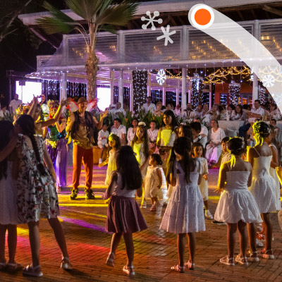 Familias, vestidas con prendas blancas, están en medio de una plazoleta, bailando y compartiendo juntos en un evento de Lagosol