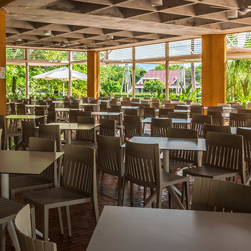 Sillas y mesas cuadradas de color gris ubicadas en el restaurante del Hotel Lagosol