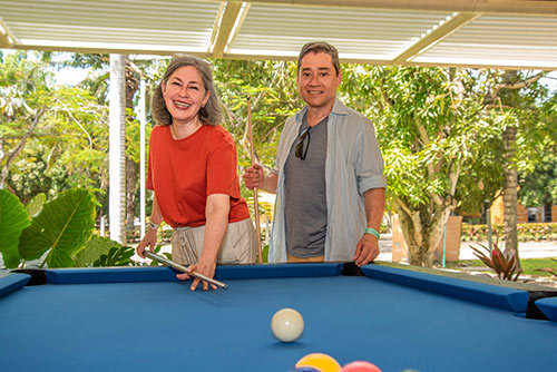 Pareja de adultos mayores jugando pool, una de las actividades incluidas en los planes de fin de semana del Hotel Lagosol