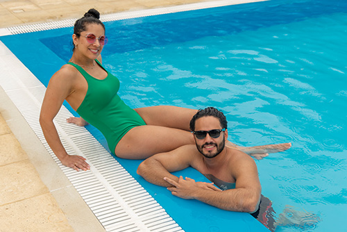 Pareja posando mientras comparten tiempo dentro de la piscina y aprovechan los planes en oferta por 5 días en Lagosol y Lagomar. Ambos tienen gafas de sol y disfrutan de un día soleado