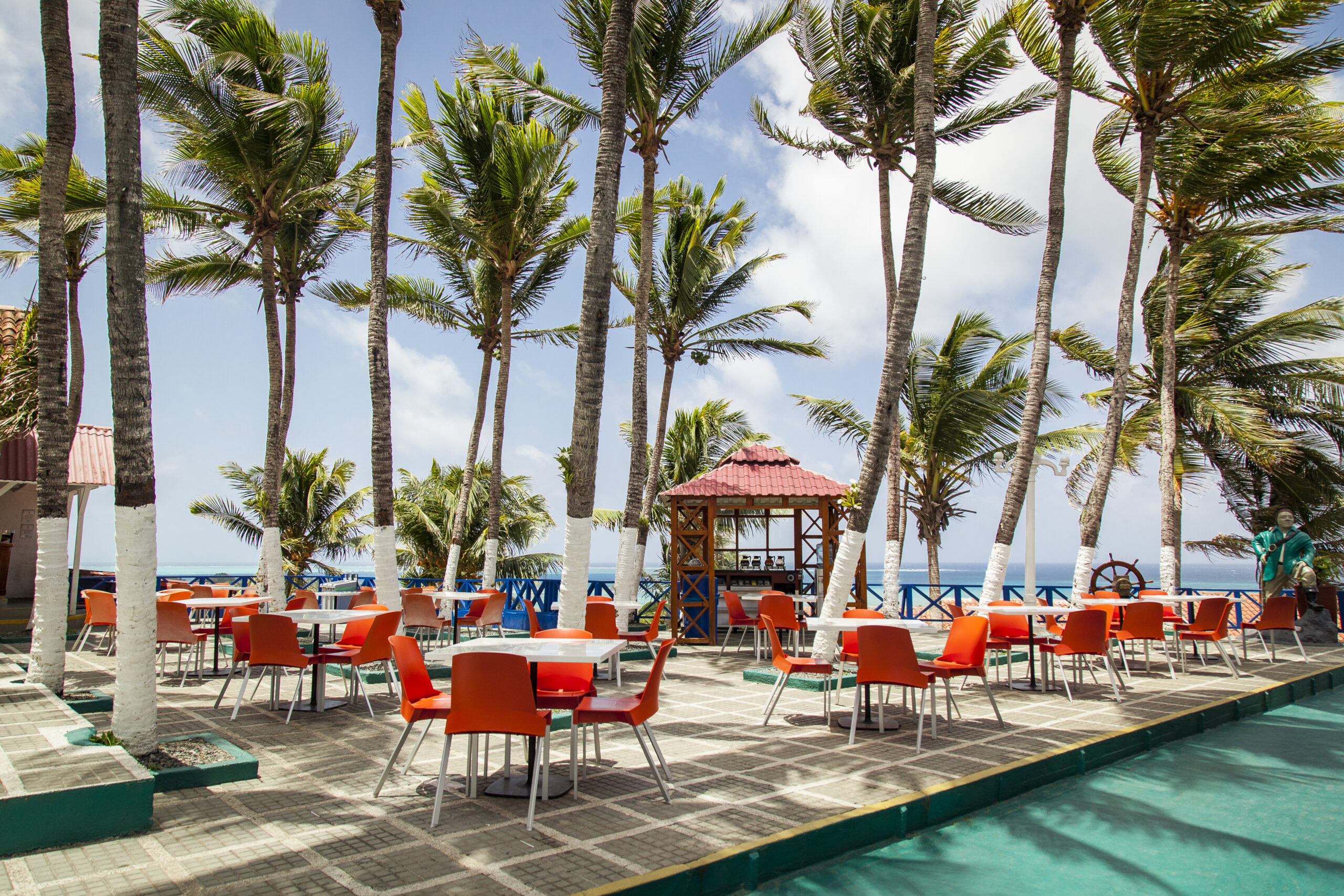 Terrazas del hotel con mesas al aire libre y vista al mar, parte de los paquetes de hoteles Sol Caribe con descuento para viajar a San Andrés