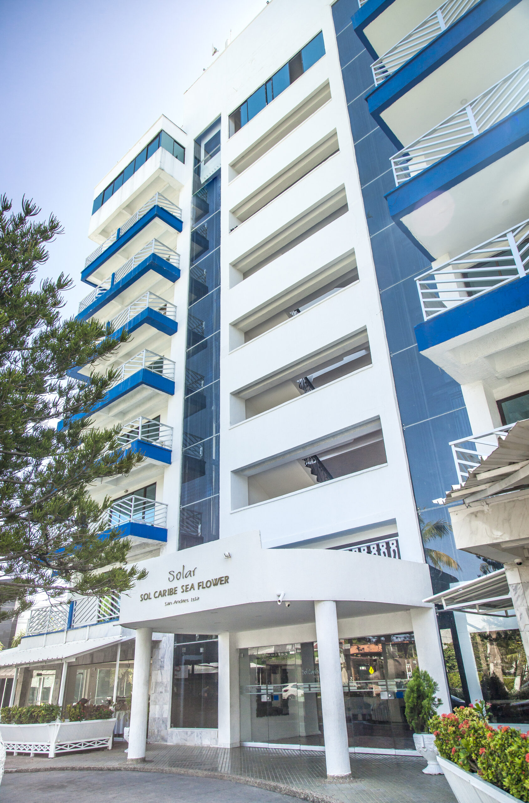 Fachada principal del Hotel con estructura blanca y detalles azules, ubicada en una zona urbana de la isla y destacada dentro de las promociones hoteles Sol Caribe Compensar