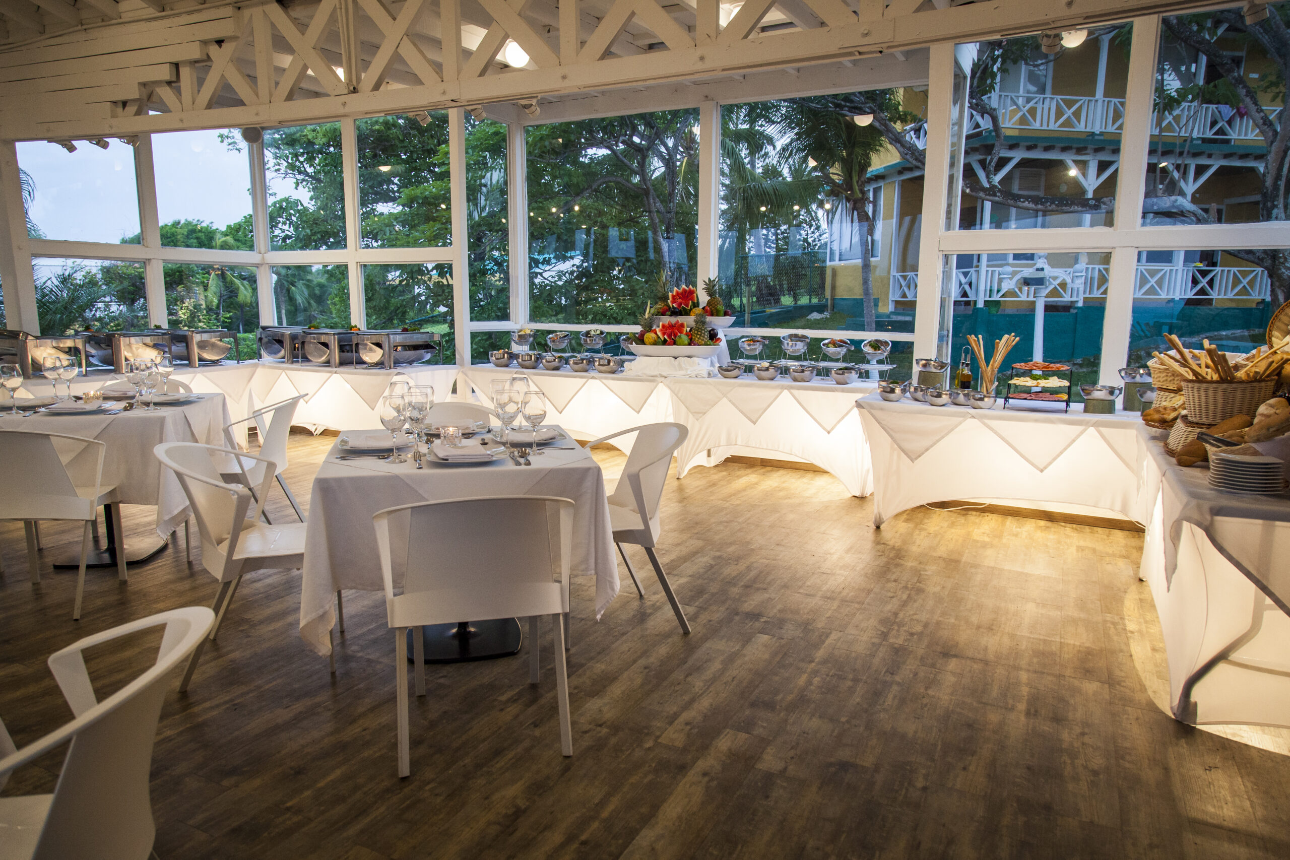 Restaurante del hotel con mesas blancas y vista exterior, incluido en la oferta de hoteles en San Andrés Compensar para planes gastronómicos y alojamiento