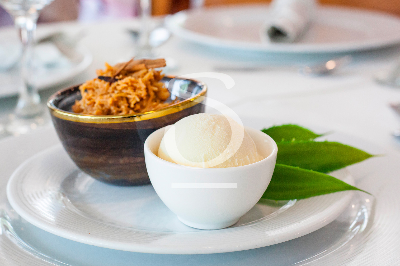 Plato servido en vajilla blanca con helado y acompañamientos, presentado sobre una mesa elegante del restaurante del hotel, como parte de la experiencia gastronómica incluida en el paquete de viaje a San Andrés Compensar
