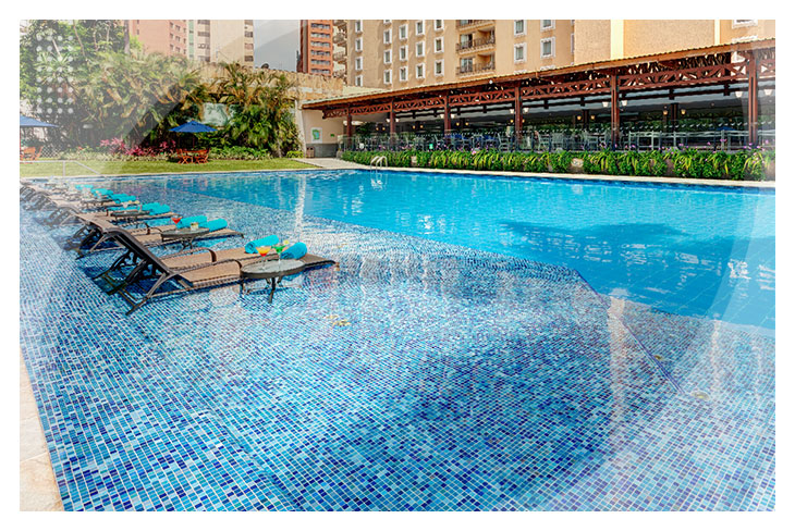Piscina de agua cristalina al aire libre con sillas asoleadorasy toallas azules, para quienes buscan ofertas para reservar en el Hotel Intercontinental y disfrutar del buen clima