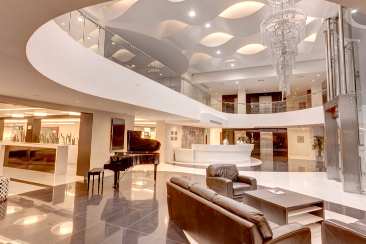Lobby moderno con sofás, pisos brillantes y diseño contemporáneo, un espacio representativo de los hoteles Estelar Perú enfocado en confort y elegancia