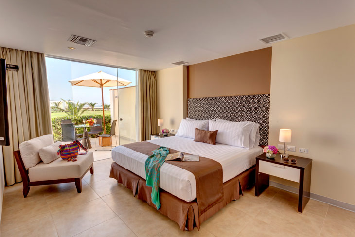 Habitación con salida a terraza privada, cama doble y área de descanso, pensada para quienes buscan descuentos en la reserva de apartamentos Estelar Perú